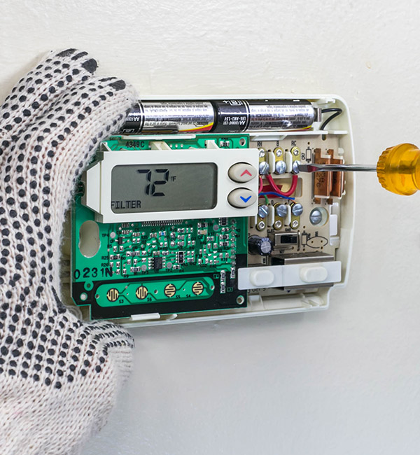 Technician repairing a thermostat